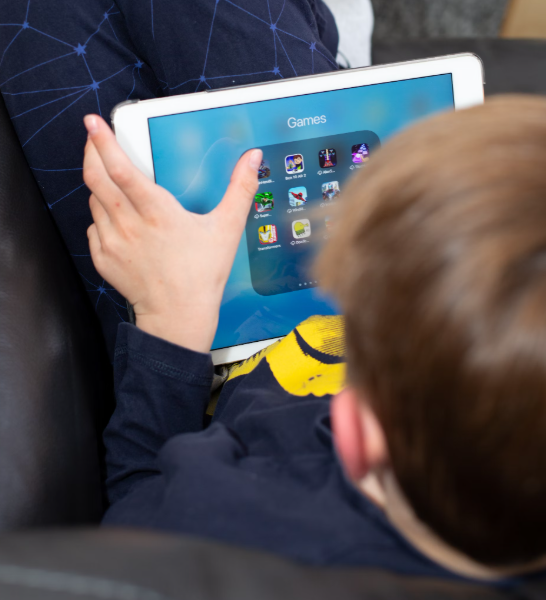 A child playing games on an ipad, themes discussed in this journal article led by Professor Sarah Mills